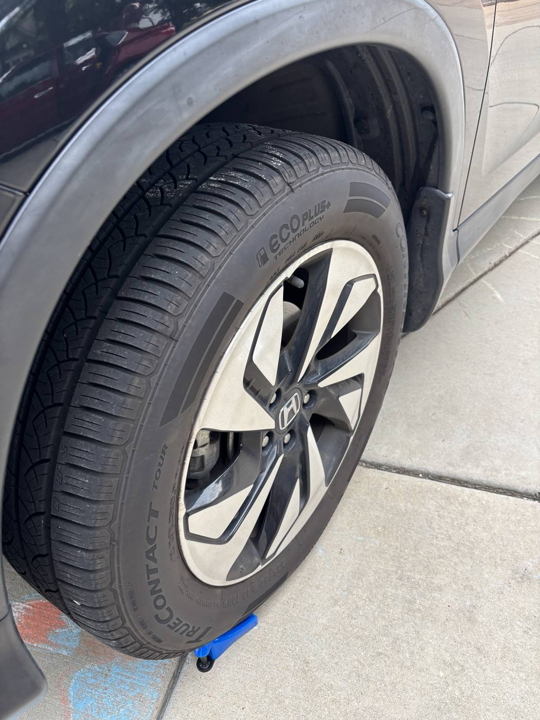 Brake-dust covered wheel and dull tire before detailing