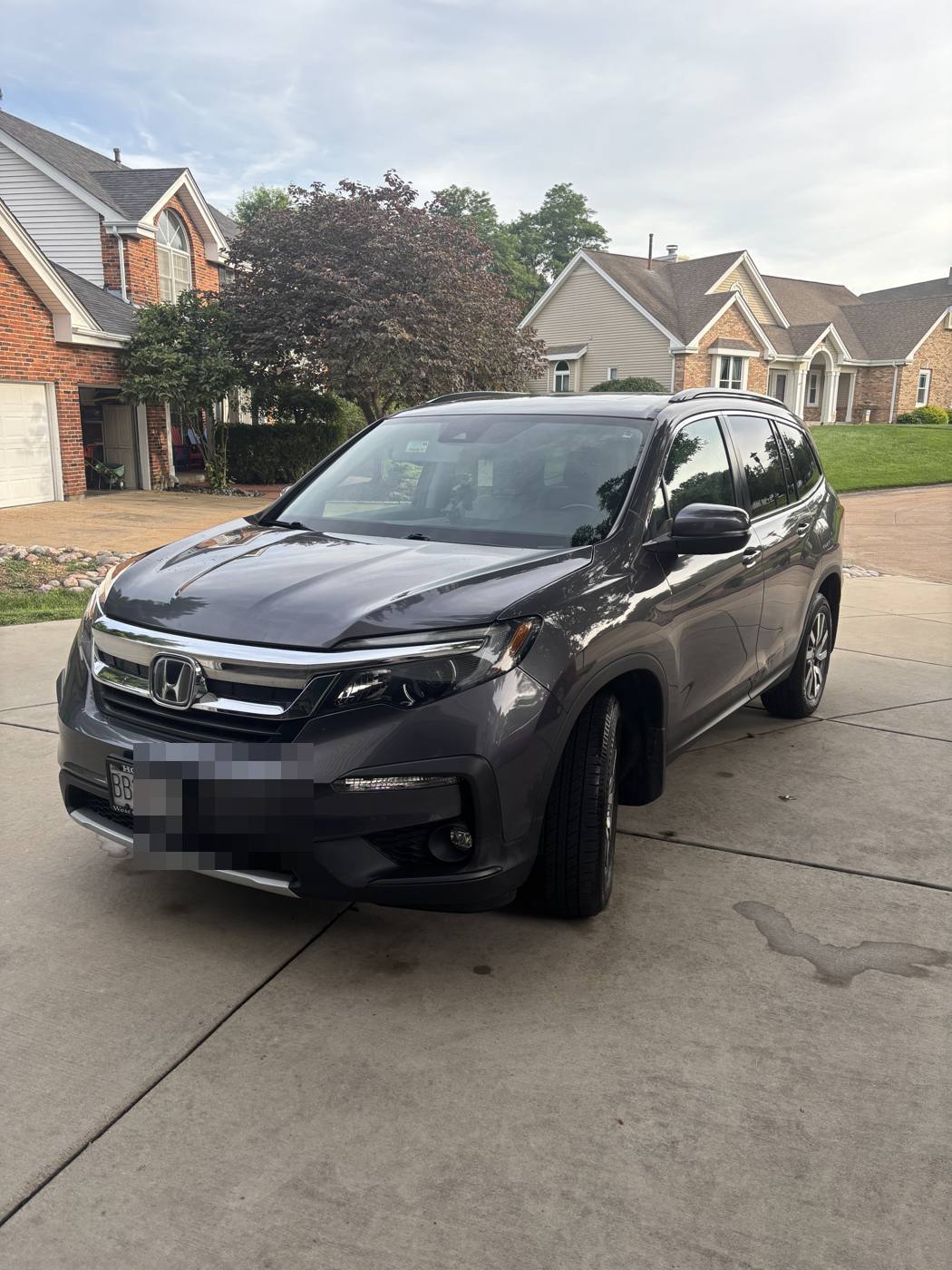 Gray Honda Pilot gleaming in the driveway after a full detail