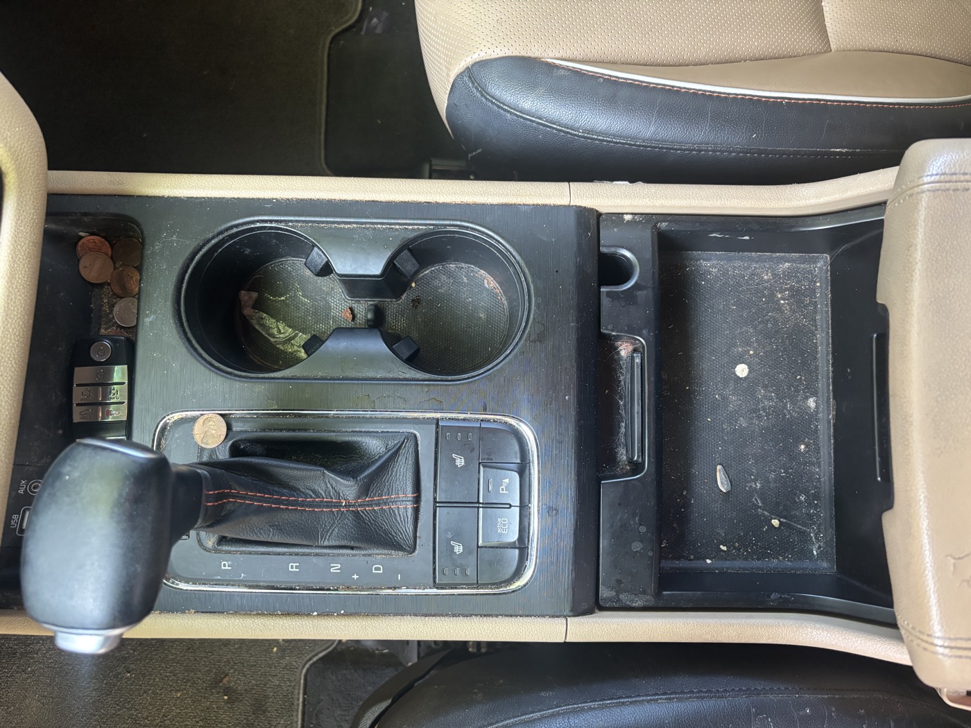 Front center console with dirt, coins and grime before detailing